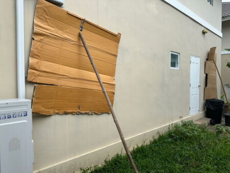 ใช้ลังกระดาษ ปิดรอบบ้าน ป้องกันหน้าต่าง ส่วนที่เป็นกระจก เพื่อไม่ให้เศษหินกระเด็นใส่